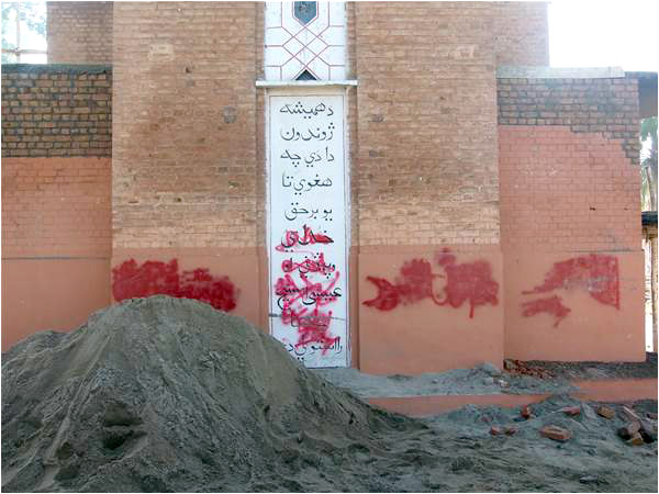 The spray painted wall of the Mardan Church that was torched by a mob last year