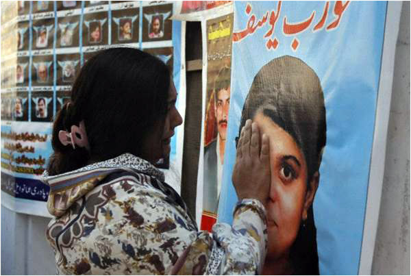 A woman cries looking at the picture of her daughter who was killed in the September 22 attack on the All Saints Church in Peshawar