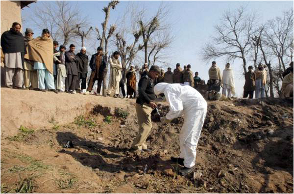 A bomb disposal squad official looks at the site of a Taliban attack on a police officer's house in Peshawar