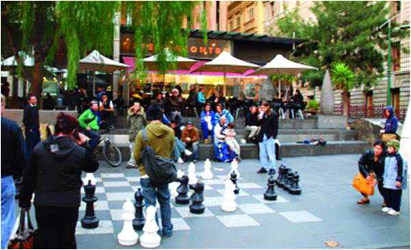In the middle of one of the busiest sidewalks in Melbourne, people take time to stop and play chess, watch chess or just watch people