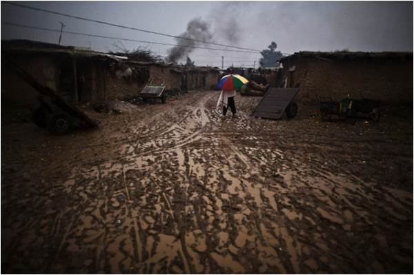 A refugee walks towards his home in a slum in the outskirts of Islamabad