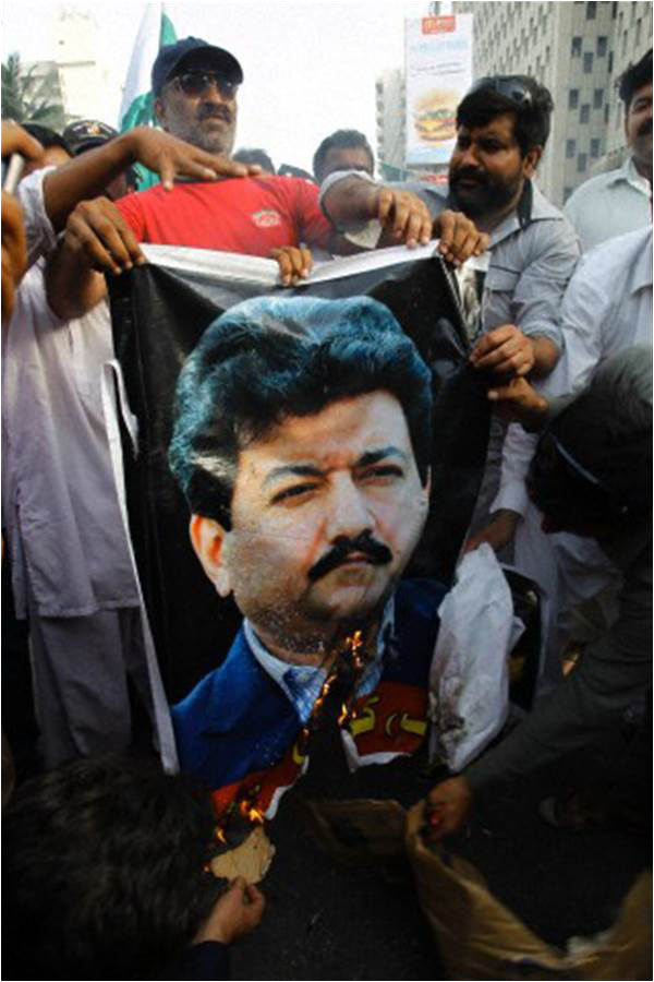 Protestors supporting ISI burn a poster of Hamid Mir in Karachi