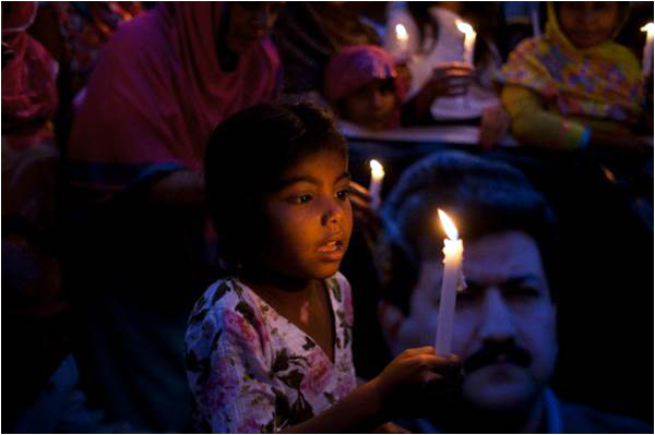 Women and children hold a candle-lit vigil in support of Hamid Mir on April 24 in Karachi