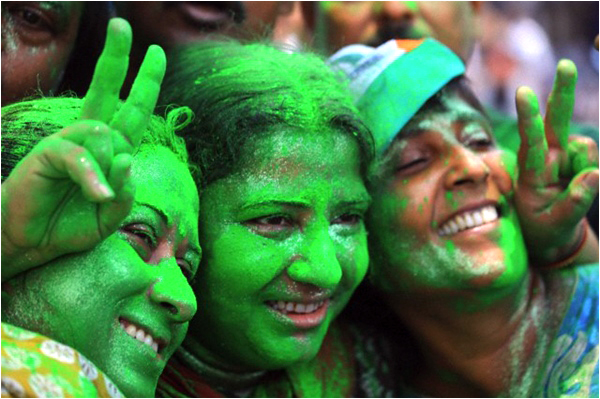 Trinamool Congress Party supporters paint their faces green to celebrate election results near a counting station in Calcutta