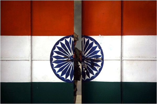 An Indian Border Security Force soldier opens a gate at the border with Pakistan