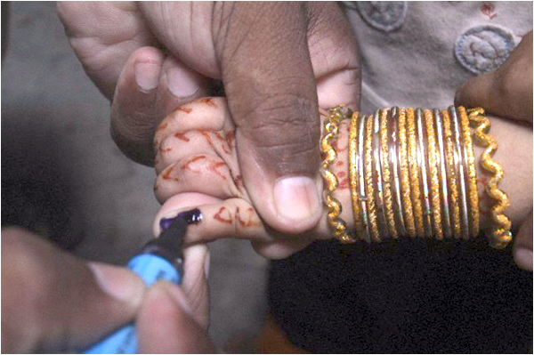 A health worker marks a finger of a displaced child after administering polio vaccine drops
