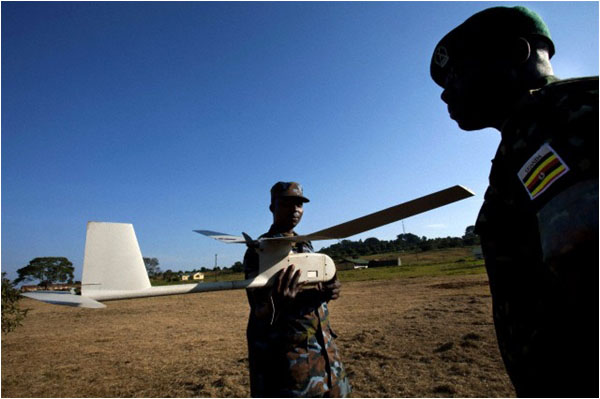 Ugandan soldiers hold a small US made drone used in Somalia, during a visit by Hilary Clinton in 2012