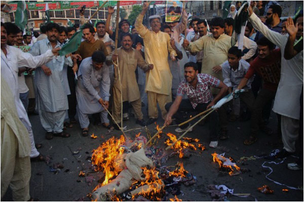 Supporters of the PML-N burn an effigy during a protest in support of the government on August 11