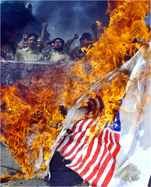 Pakistani activists burn a US flag at a protest in Peshawar