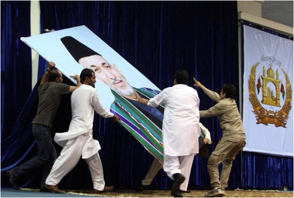Supporters of Afghan presidential candidate Dr Abdullah Abdullah remove the portrait of Afghan President Hamid Karzai from the venue of a protest speech after the preliminary election results in July