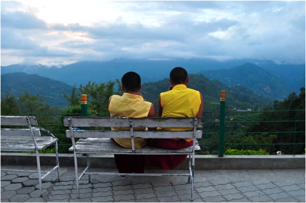 Buddhist monks ending their day with a quiet view of the valley. They're wearing only half their robes since studies for the day have ended