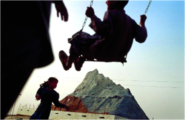 Children play in front of a large-scale replica of the Chaghi Mountain at the Askari Amusement Park in Quetta