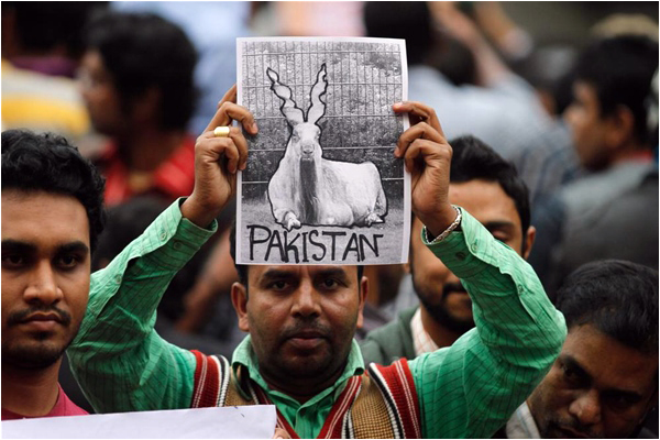 A Bangladeshi man holds up a poster