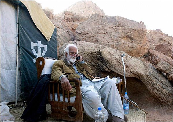 The Baloch rebel leader Nawab Akbar Khan Bugti speaks on a phone outside his compound in the remote region of the restive Balochistan province