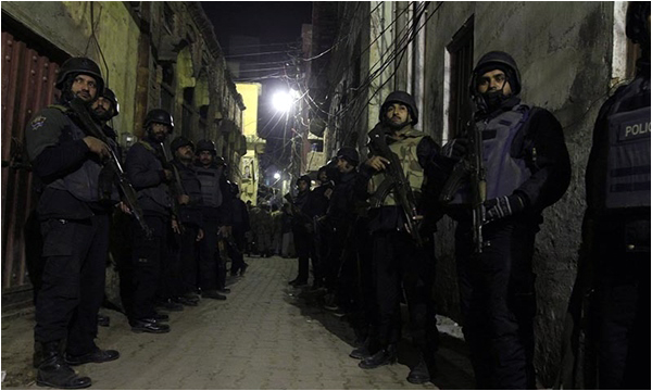 Policemen stand guard near the site of a bomb attack in Rawalpindi January 9, 2015