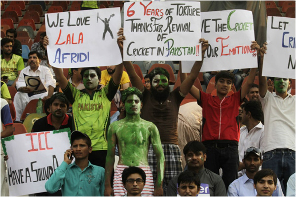 Cricket fans holding banners inside Gaddafi Stadium ahead of the first T20I