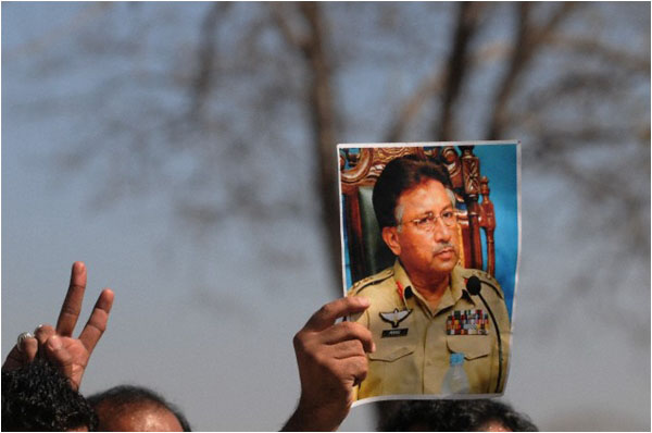 A supporter raises a portrait of Musharraf outside a court during a hearing in 2014