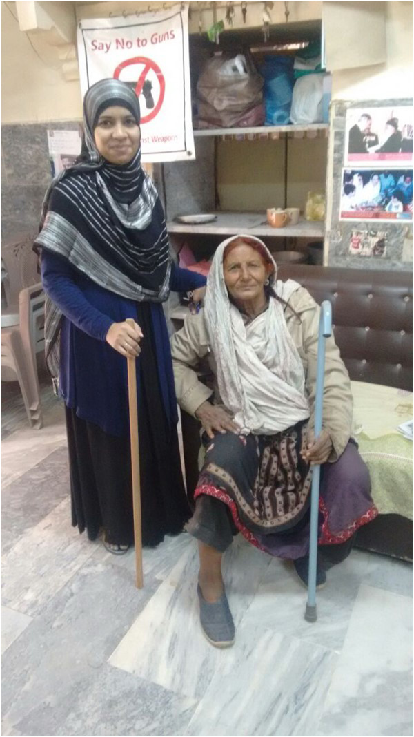 Aiding the elderly - a woman receieves a free walking stick from the Edhi Foundation