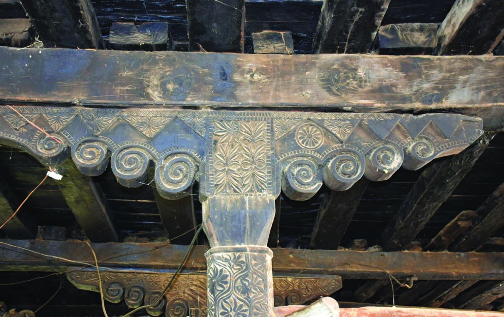 Decorated column with triple voluted capital with cross engraving on the left side